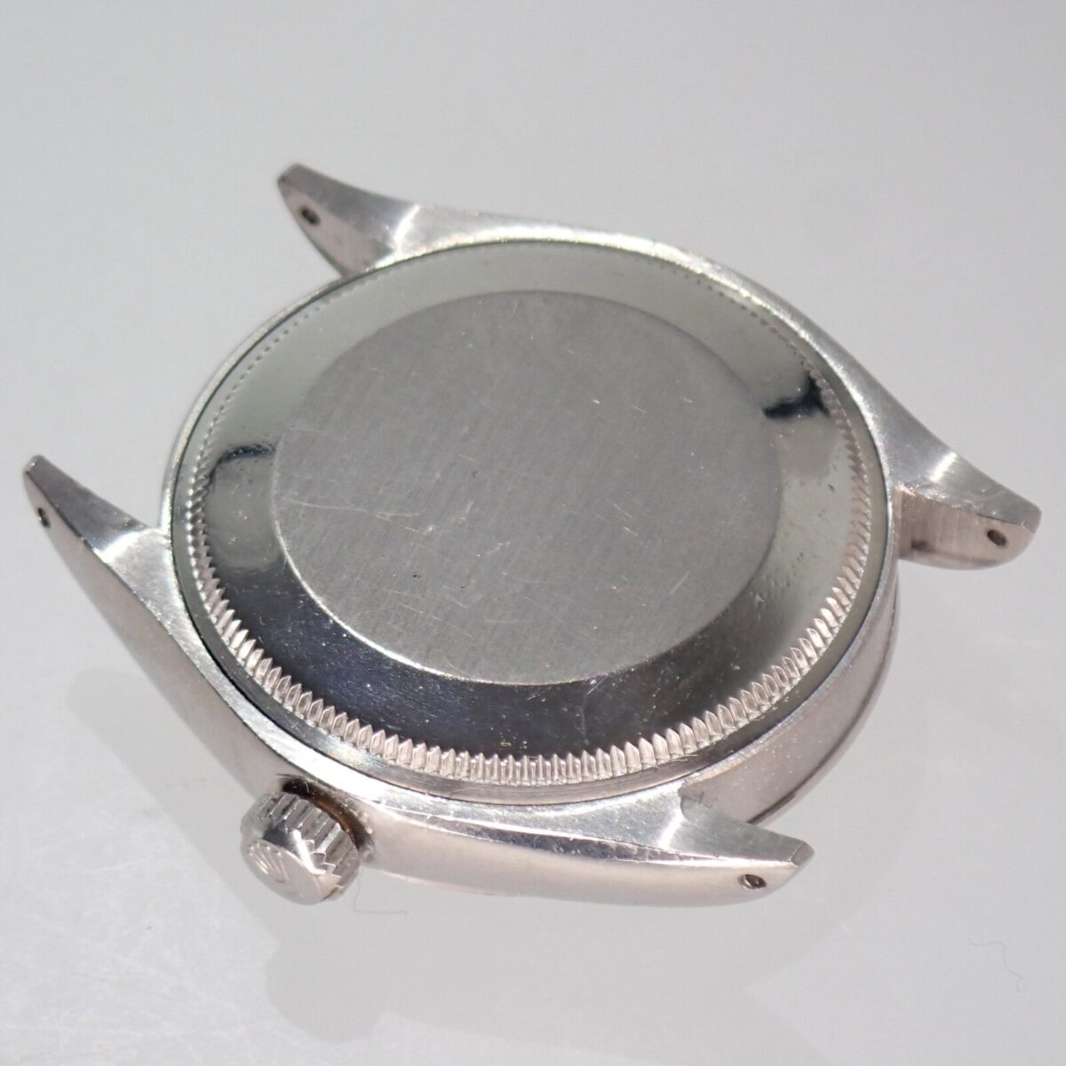 ともなんだ、シルバーの腕時計ケース、裏側の画像。高品質な時計ケースの詳細と素材感が伝わる写真です。高級腕時計のパーツや修理に役立つ情報を提供します。.