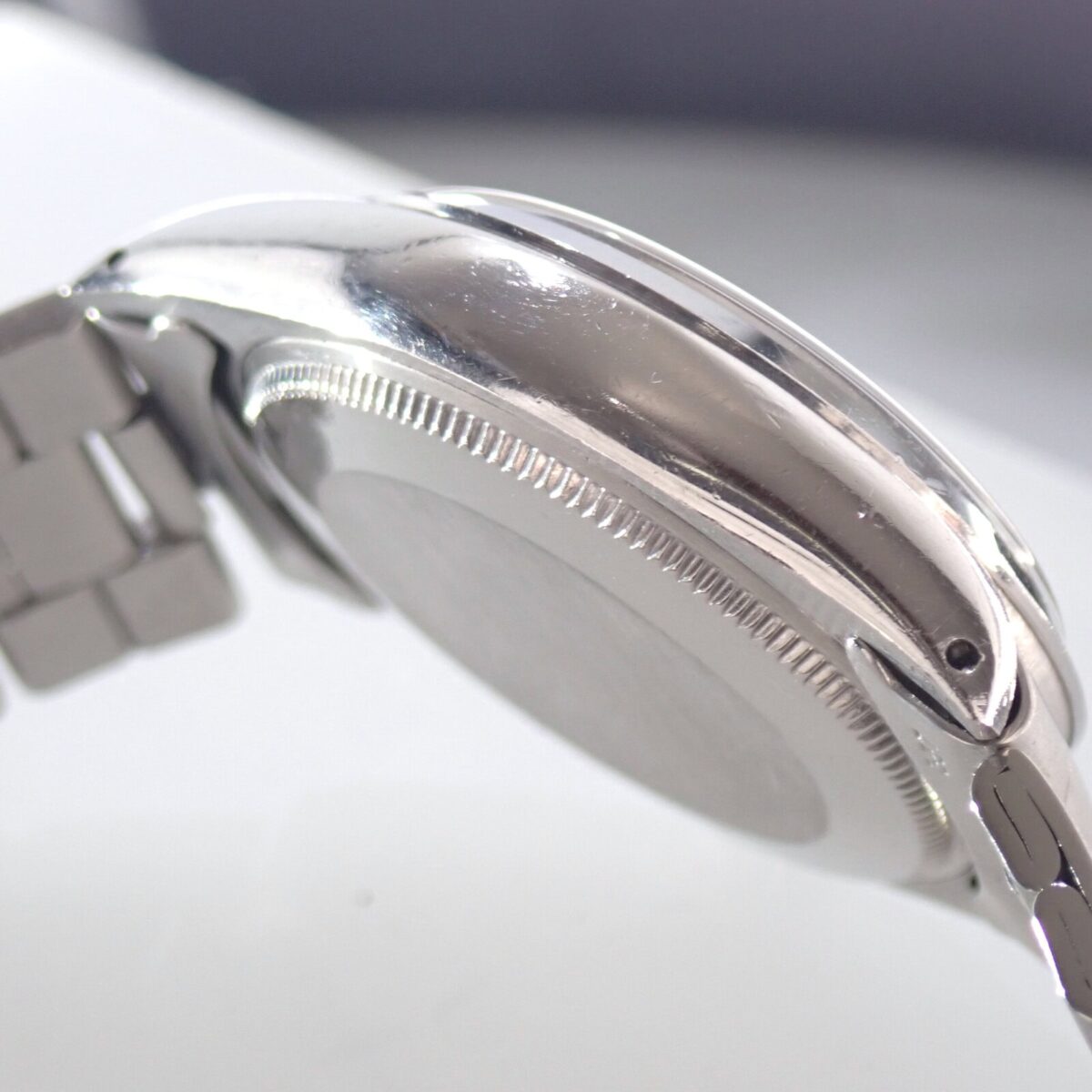 ステンレス製腕時計の側面とバンドの詳細なクローズアップ画像.