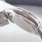 ステンレス製腕時計の側面とバンドの詳細なクローズアップ画像.