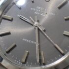 018 ロレックスの腕時計アップ写真、耐久性と高級感を象徴するシルバーダイヤルとクロノグラフの詳細。高品質な素材と精密な製造技術を示す時計画像。.