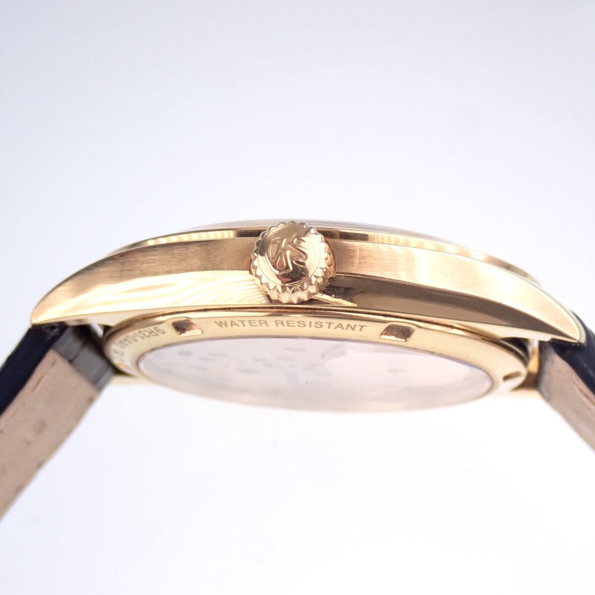 金色のレザーベルト付き高級腕時計の斜め横顔、ウォーターレジスタント表示あり.