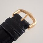 金色のバックルと黒革ベルトのアップ写真.